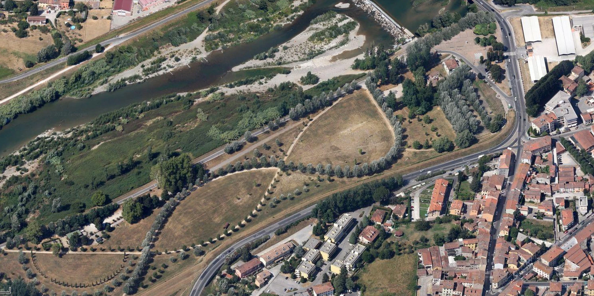 Percorso in ghiaia tra alberature e radure nel Parco dell'Infinito lungo il Serchio a Lucca