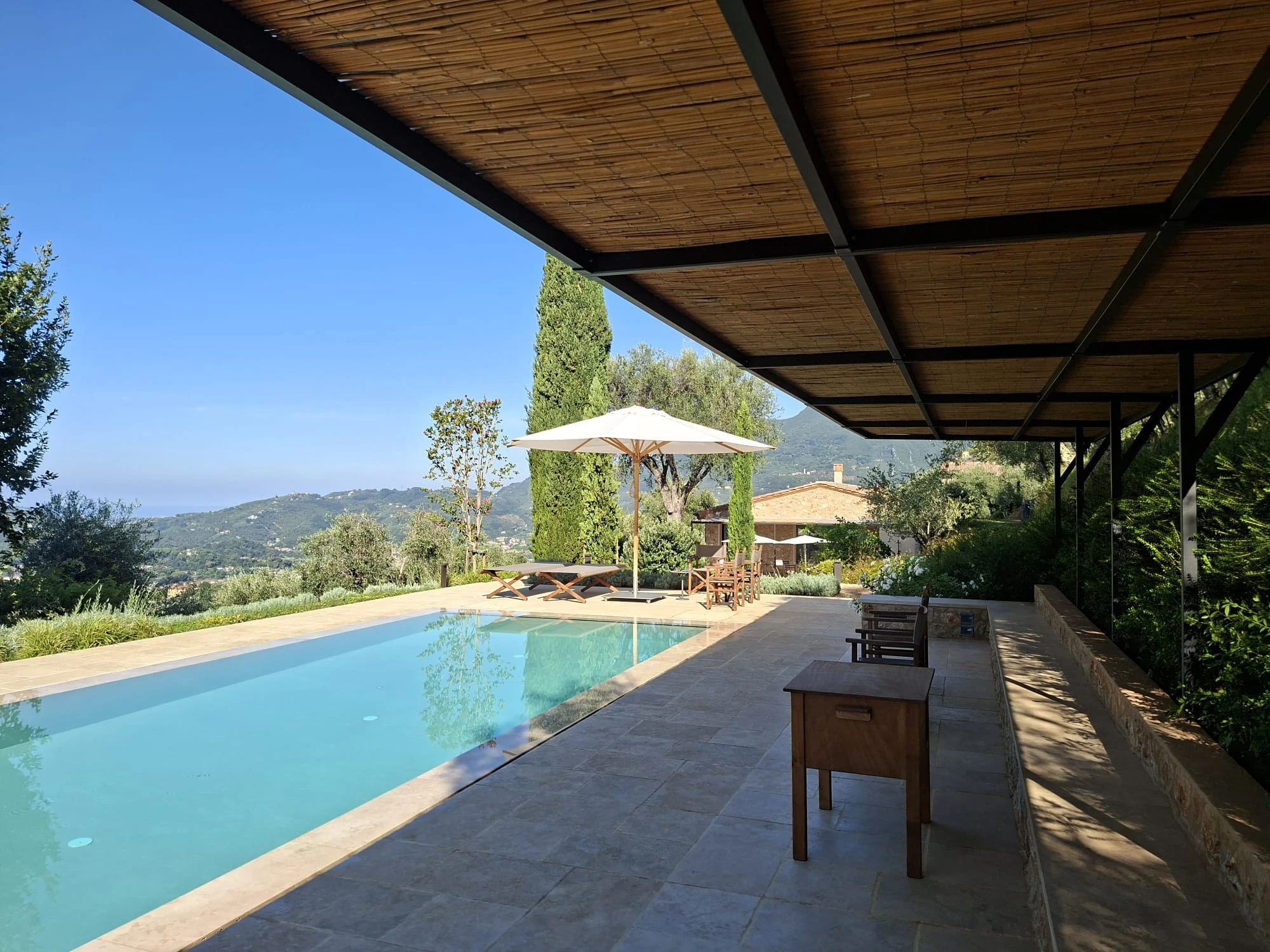 Pergolato in canna sopra la piscina con vista panoramica su colline e mare